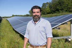 Dynamic Organics Morgan Casella in front of solar panels