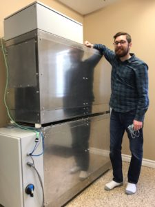 Neothermal Energy Storage co-founder and CEO Louis Desgrosseilliers with a boiler-tied ETS prototype system in Halifax, Nova Scotia. The company won DeltaClimeVT Energy 2021. Photo courtesy of Neothermal Energy Storage.